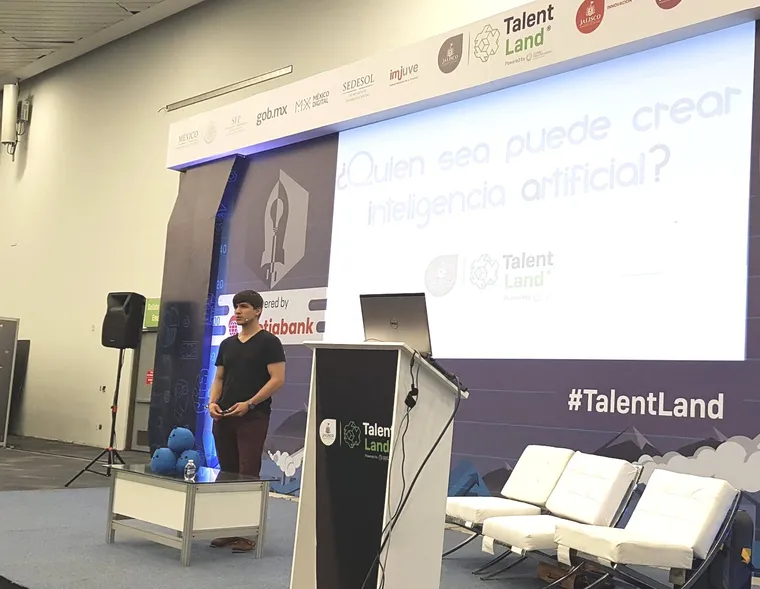 Jorge Sierra en el escenario de Talent Land, frente a una pantalla que pregunta «¿Quién sea puede crear inteligencia artificial?»
